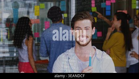 Mit einem bärtigen Mann im Hoodie, der einen Marker an der Glaswand hält, mit Haftnotizen und Code-Overlay. Zusammenarbeit, Brainstorming, Teamarbeit, Ideenfindung, d Stockfoto