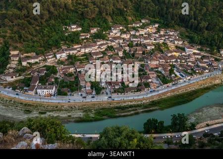 Blick aus der Vogelperspektive auf die osmanischen Häuser von Berat und den Fluss Osum in Green Hillside Landscape Stockfoto