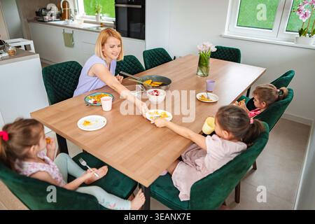 Familie genießt gemeinsam Frühstück in einer gemütlichen Küche Stockfoto