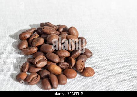 Geröstete Kaffeebohnen auf einem strukturierten, leichten Stoff wie Sacktuch Stockfoto