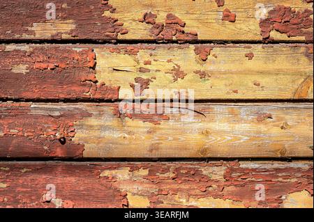 Vintage-Textur von zerrissenen Holzdielen mit abblätternder roter Farbe und verwittertem Holzmaserung Hintergrund Stockfoto