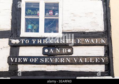 Traditionelle gusseiserne Richtungsschilder an einem Fachwerkgebäude in Bridgnorth, die auf den Castle Walk und den Blick auf das Severn Valley zeigen Stockfoto