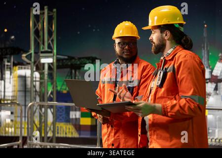 Experten für Industriebohrschiffe arbeiten zusammen, um die Integrität der Ausrüstung zu überprüfen. Mitarbeiter von Offshore-Plattformen sammeln Brainstorming, führen vorbeugende Wartungsprüfungen an Maschinen durch, um die Sicherheit zu gewährleisten Stockfoto