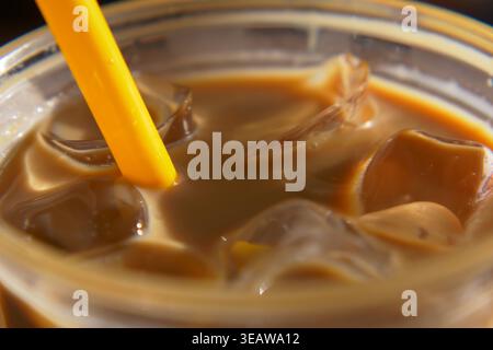 Genießen Sie Eiskaffee mit Plastikstroh an einem warmen Tag Stockfoto
