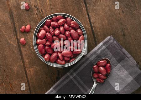 Rote Kidneybohnen aus Dosen, serviert in einem minimalistischen rustikalen Stil auf einem Holztisch in einer Dose mit Blick auf FlatLay. Eine offene Dose, die bis zum Rand gefüllt ist Stockfoto