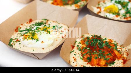 Collage aus verschiedenen Speisen mit Hummus und Belägen zum Teilen bei einer lokalen Veranstaltung Stockfoto