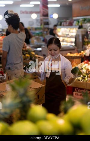 Balinesische Arbeiterin mit Wassermelone im Supermarkt auf Bali Stockfoto