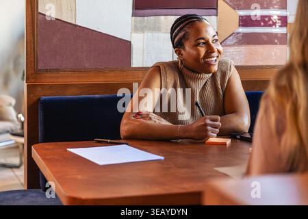 Lächelnde Geschäftsfrau im Gespräch mit einem Kollegen Stockfoto