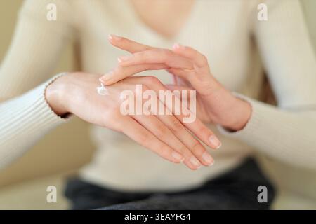 Frau, die feuchtigkeitsspendende Creme auf die Hände aufträgt. Nahaufnahme einer Frau, die Handcreme aufträgt, Hautpflege, Hydration, Schönheitsroutine und weich gesund zeigt Stockfoto