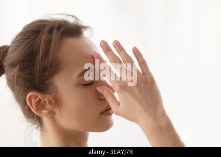 Junge Frau, die Achtsamkeit und Entspannungstechniken im Innenbereich in sanfter Beleuchtung übt Stockfoto