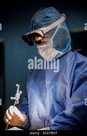 Chirurg, der robotergestützte Wirbelsäulenchirurgie mit MediThinQ Scopeye Smart Brille im OP durchführt Stockfoto