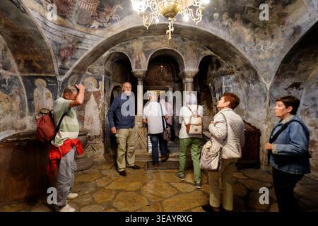 Gruppe von Touristen im Kloster Saint Naum, die Fresken im alten byzantinischen Stil und religiöse Ikonen auf Steinmauern in der Nähe von Ohrid, Mazedonien, Europa bewundern Stockfoto