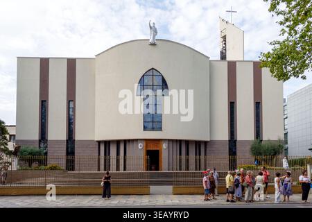 Moderne Architektur der St. Paul's Cathedral in Tirana, Albanien, mit ihrer einzigartigen geschwungenen Fassade und religiösen Statue unter einem bewölkten Himmel Stockfoto