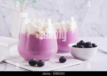 Cocktail mit Heidelbeerjoghurt und Marshmallows in einem Glas auf dem Tisch Stockfoto