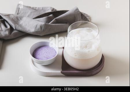 Trübe rosa Matcha in einem Glas und Pulver in einer Schüssel auf dem Tisch Stockfoto