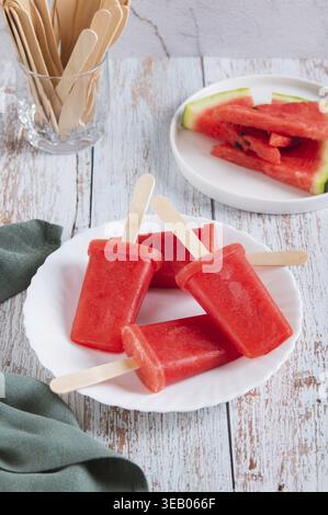 Rote Wassermelonen-Eis auf einem Teller auf dem Tisch, vertikale Ansicht Stockfoto