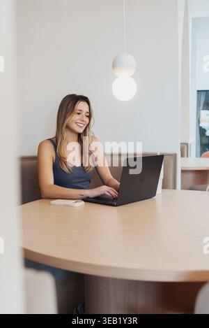 Glückliche Frau, Die In Online-Gesprächen Teilgenommen Hat. Junge Frau Genießt Fröhlichen Videochat Auf Ihrem Gerät. Ehrliches Porträt Der Lächelnden Jungen Frau Während Stockfoto