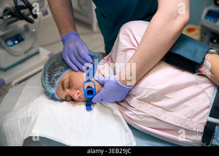 Junge kaukasische Frau in blaugrün-Peelings, die Patienten im Krankenhaus betreut Stockfoto