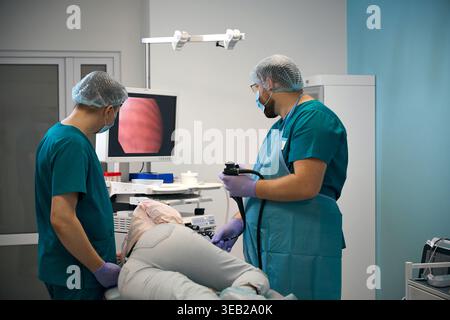 Mediziner, die Endoskopie am Patienten im Krankenhaus durchführen Stockfoto