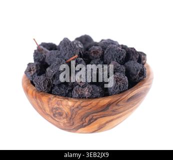 Getrocknete Aronia-Beeren, isoliert auf weißem Hintergrund. Trocknen Sie die schwarze Apfelbeere in einer Holzschale. Beschneidungspfad Stockfoto