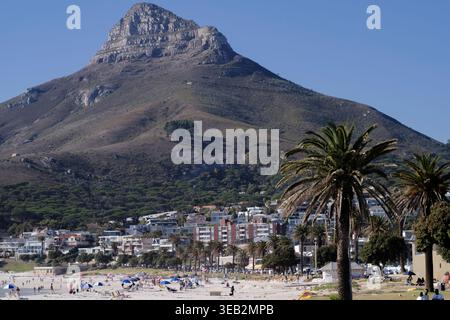 Typischer Tag am Strand in Camps Bay, Kapstadt, Südafrika. Löwenkopf im Hintergrund vor blauem Himmel. Stockfoto