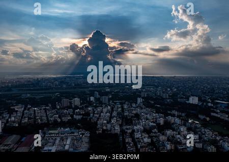 Die Sonne geht über einer Wolkendecke auf und wirft weiche Schatten über Dhaka Stadt in einer ruhigen Drohnenperspektive. Bangladesch Stockfoto