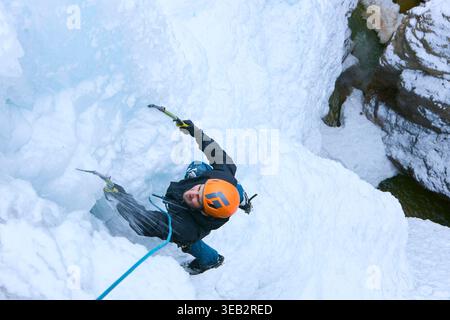 Bergsteiger Eisklettern auf gefrorenen Wasserfällen mit Eisäxten Stockfoto
