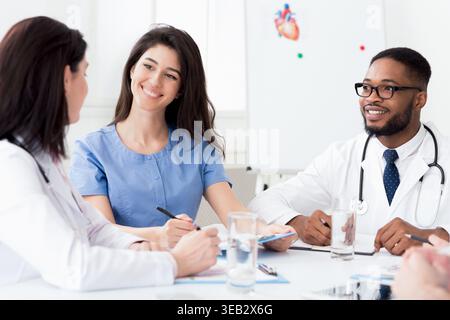 Kardiologie-Konferenz. Verschiedene Ärzte, die sich bei einem Meeting unterhalten Stockfoto