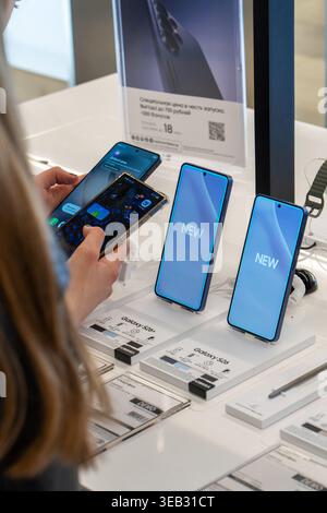 Der Kunde wählt ein Smartphone zum Kauf aus und vergleicht die neuesten Samsung Galaxy Smartphones mit ihrem eigenen Mobiltelefon. Minsk, Weißrussland - 30. März 2026 Stockfoto