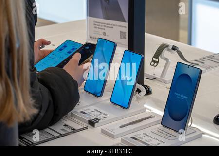 Der Kunde wählt ein Smartphone zum Kauf aus und vergleicht die neuesten Samsung Galaxy Smartphones mit ihrem eigenen Mobiltelefon. Minsk, Weißrussland - 30. März 2026 Stockfoto