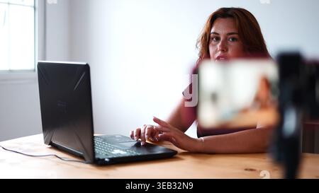 Frau erstellt Online-Videoinhalte, Live-Streaming auf Smartphone mit Laptop Stockfoto