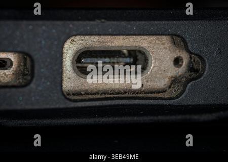 Makroansicht eines schmutzigen und abgenutzten USB-C-Ladeanschlusses an einem elektronischen Gerät Stockfoto