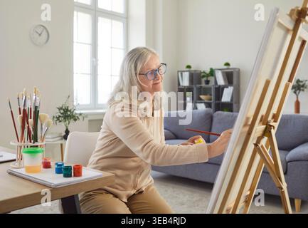 Eine Ältere Künstlerin Malte Zu Hause Auf Leinwand Stockfoto