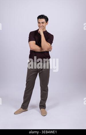 Mann, der in einer entspannten Pose steht und wegschaut Stockfoto