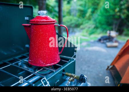 Rote Kaffeekanne auf einem Herd auf einem Campingplatz an einem See im Norden von Minnesota Stockfoto