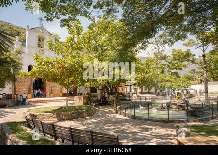 Jordanien, kolumbien - agosto 30, 2025 Kolonialarchitektur bildet einen pulsierenden Stadtplatz mit einer historischen Kirche, üppigen Bäumen, einem dekorativen Brunnen, Stockfoto