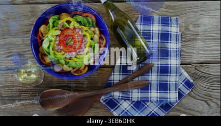 Die blaue Schüssel mit Salat, Tomate, Zwiebeln, Dressing, links auf dem Tisch sitzen, Weinflasche Stockfoto