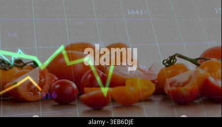 Zeigt ganze in Scheiben geschnittene Kirschtomaten auf einem hellen Brett mit Stängel, Samen und grünen gelben Linien Stockfoto