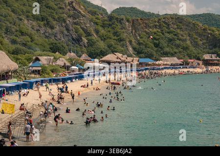 Santa marta, kolumbien - Noviembre 02, 2025 Personen genießen warmes Meerwasser und Sandstrand in playa blanca, santa marta, kolumbien. Strandhütten säumen das Hotel Stockfoto