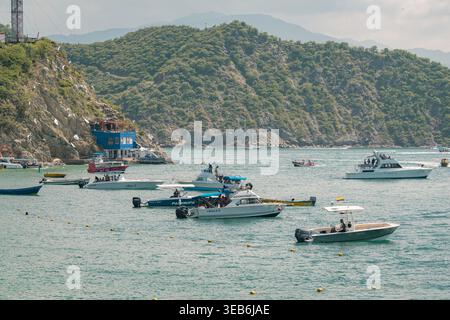 Santa marta, kolumbien - noviembre 02, 2025 zahlreiche Boote ankerten und navigierten im klaren Wasser der Bucht von santa marta, umgeben von üppig grünen mountai Stockfoto