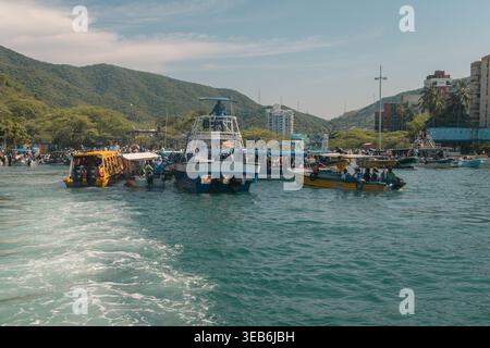 Santa marta, kolumbien - noviembre 02, 2025 Boote transportieren Touristen in der Bucht von rodadero, santa marta, kolumbien, mit Bergen und Stadtgebäuden Stockfoto