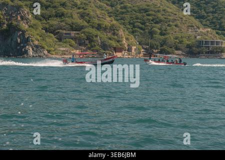 Santa marta, kolumbien - noviembre 02, 2025 zwei Motorboote fahren Touristen über das blaue Meer in Richtung grüne santa marta Küste, sonniger tropischer Ausflug mit Stockfoto