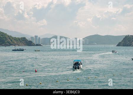 Santa marta, kolumbien - noviembre 02, 2025 Boote, die durch das klare Wasser des El rodadero Strandes in santa marta, kolumbien fahren, mit den Gebäuden der Küstenstadt A Stockfoto