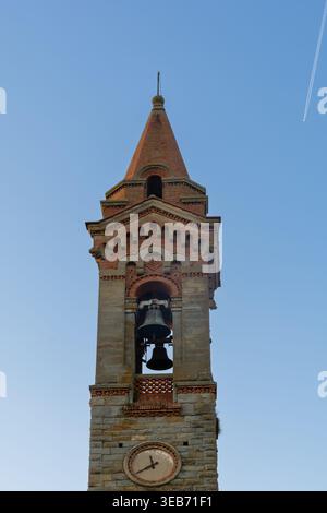Blick auf den historischen Steinglockenturm mit einer Uhr und zwei Glocken vor einem klaren blauen Himmel in Piantravigne, Toskana, Italien. Stockfoto