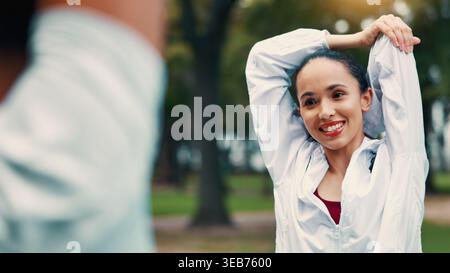 Stretching, Frau und Personal Trainer im Park mit Kunden, Lächeln und Beginn des Trainings für Fitness. Happy, Coach und Leute im Freien mit Aufwärmen Stockfoto
