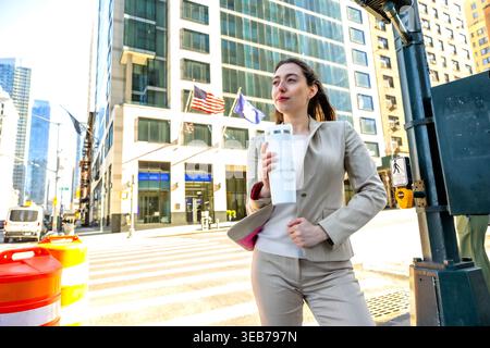 Geschäftsfrau, die auf der manhattan Street steht und einen Becher hält Stockfoto