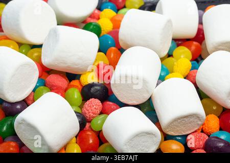 Viele bunte runde Süßigkeiten und weiße Marshmallows von oben Stockfoto