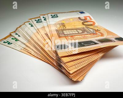 Nahaufnahme der gestapelten fünfzig Euro-Banknoten, die ordentlich auf einer Ebenen Fläche in einer gut beleuchteten Umgebung angeordnet sind Stockfoto