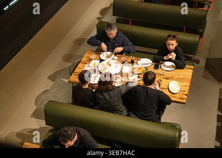 Batumi, georgien 21. april 2026: Familie und Freunde teilen georgisches Khinkali und andere Gerichte in einem modernen batumi Restaurant mit Blick auf Convivi aus der Höhe Stockfoto
