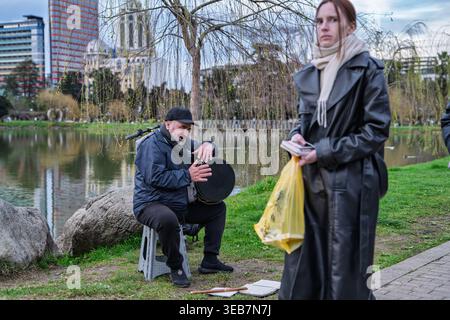 Batumi, georgia 21. april 2026: Straßenmusiker unterhält Passanten am See in batumi, georgia. Die Leute genießen Musik in einem öffentlichen Park setti Stockfoto